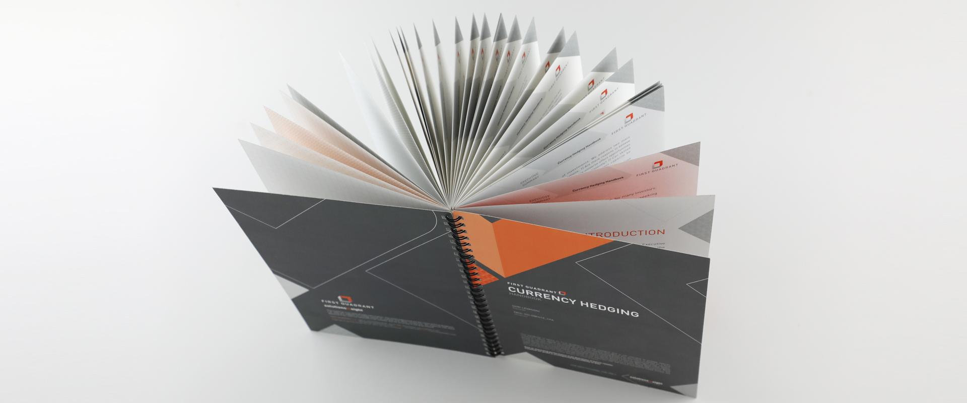An overhead view of a handbook with the front and back cover wide open and the pages spread out.